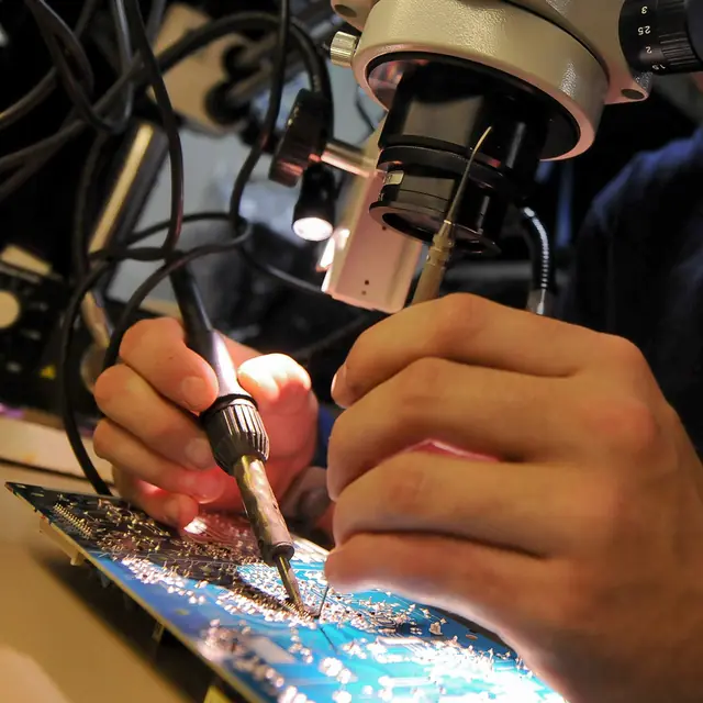 Soldadura de una placa electrónica bajo el microscopio